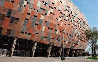 Fachada do Soccer City recebe pigmentos coloridos e agrada esteticamente